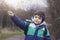 Active boy pointing wooden stick up to the sky while walking in forest park,A Child boy having fun playing outdoor activity,, Pres