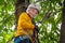 Active brave little boy enjoying climbing at treetop adventure park