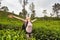 Active caucasian blonde woman enjoing fresh air and pristine nature while tracking among tea plantaitons near Ella, Sri