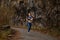 Active caucasian female with red hair doing exercises jogging in nature alone, side view