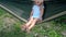 Active Caucasian Little Girl Swinging in Hammock Hanging on Garden Trees