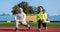 Active children in activewear stand in lunge position at athletics stadium, childrens sports school