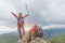 Active climbers enjoy the scenery. Male and female backpackers with backpacks and crutches on top of a mountain