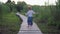 Active cute little child boy walking on wooden bridge barefoot in open air among high vegetation