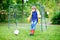 Active cute little kid boy playing soccer and football and having fun