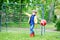 Active cute little kid boy playing soccer and football and having fun