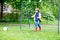 Active cute little kid boy playing soccer and football and having fun