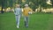 Active elderly men walking in park with football, sport hobby, health care