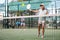 Active elderly woman playing padel tennis on open court