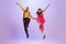 Active and emotional couple in colorful retro style costumes dancing incendiary dances  on purple background in