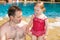 Active father teaching his toddler daughter to swim in pool on tropical resort.