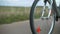 active female cyclist pedals a bicycle while riding on a road outside city, close-up