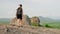 Active female hiker descends mountain trail with rich green landscape, Sigiriya Rock background. Solo traveler explores