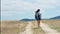 Active female hiker enjoying mountain landscape surrounded by dried grass rear view