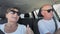 active female and male pensioners having fun while traveling in car on way to vacation