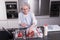 Active female pensioner is preparing and eating strawberries in