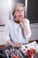 Active female pensioner is preparing and eating strawberries in