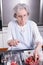 Active female pensioner is preparing strawberries in the kitchen