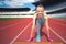 Active female runner preparing for a track contest, enjoying a workout, training and working out. Fitness girl jogging on stadium