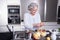 Active female senior peeling apple in the kitchen