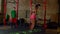 Active fit black female doing backward side straddle hop using agility ladder