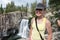 Active fit female hiker poses by Rainbow Falls in the Devils Postpile National Monument in California