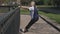 active fit senior woman do sport exercises outdoor stretching back body in park