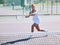 Active, fit and sporty athletic tennis player playing a friendly match at a tennis court. Female athlete learning to