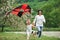 Active game. Positive female child and grandmother running with red and black colored kite in hands outdoors