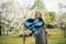 Active girl in retro dress and denim jacket in a blooming apple orchard. lifestyle activity outdoor.