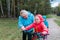 Active grandmother teaching little girls to ride bike in nature