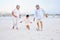 Active grandparents playing soccer on the beach with their grandson. Little boy kicking ball with his grandmother and