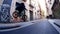 Active guy bicycler rides and jumps along empty narrow bycycle track in street