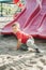 Active happy funny smiling Caucasian boy child sliding on playground schoolyard outdoors on summer sunny day. Kid having fun.