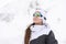 active healthy beautiful caucasian little girl with ski goggles and winter snowboarder sportswear looking up in mountain