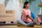 Active indian pregnant woman doing exercise or workout on yoga mat at home - concept of healthy lifestyle, fitness and
