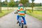 Active kid boy in safety helmet and colorful clothes on bike