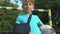 Active kid with injured arm in sling holding ball looking camera, sport injury