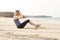 Active Lady Doing Sit-Ups by the Seaside