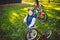 Active leisure for children in the park. A child is studying the mechanism of a mountain bike. Toddler fixing a bike in the forest