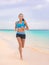 Active lifestyle young woman jogging on beach. Running barefoot on sand in Hawaii vacation travel Asian girl running on