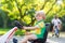 Active little boy driving pedal car in summer garden