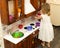 Active little preschool age child, cute toddler girl with blonde curly hair, shows playing kitchen, made of wood, plays