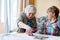 Active little preschool kid boy and grand grandmother playing card game together at home