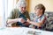 Active little preschool kid boy and grand grandmother playing card game together at home