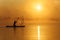 Active male paddler training on sup board during sunrise