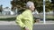 Active male pensioner with hearing aid device jogging outside