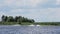 Active male is riding on waterski on water surface following boat along river