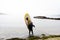 Active male surfer in wetsuit with paddleboard on sand beach enjoying healthy lifestyle extreme sport