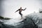 Active man in black swimsuit rides through the waves on water board